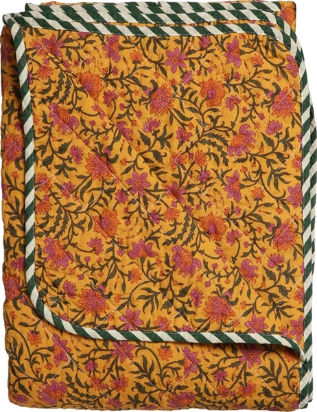 Detail van de okergele bloemenquilt en het quiltstiksel