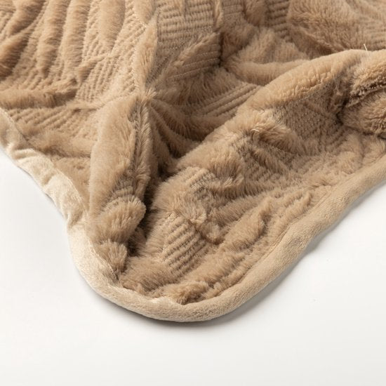 Detail van het gewatteerde bladmotief op de beige bedsprei