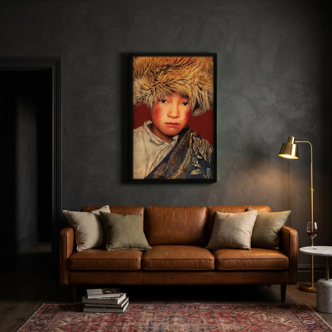 Tibetaanse jongen rood gobelin met zwarte lijst boven cognac leren bank in warme woonkamer