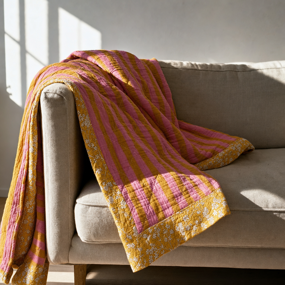 Gele bloemenquilt over een bank in het interieur