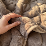 Detail van het reliëf en zachte bontlook van de bedsprei