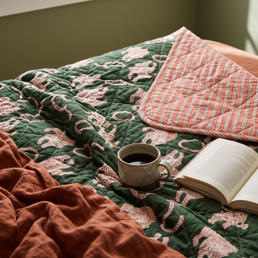 Close-up tijgerquilt op bed met omgeslagen zalmroze streepkant