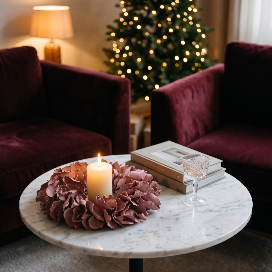 Krans 25 cm rond een kaars op een marmeren bijzettafel naast een bordeaux velvet fauteuil