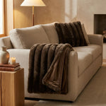 Polly bontplaid donkerbruin met matchend sierkussen op een beige bank