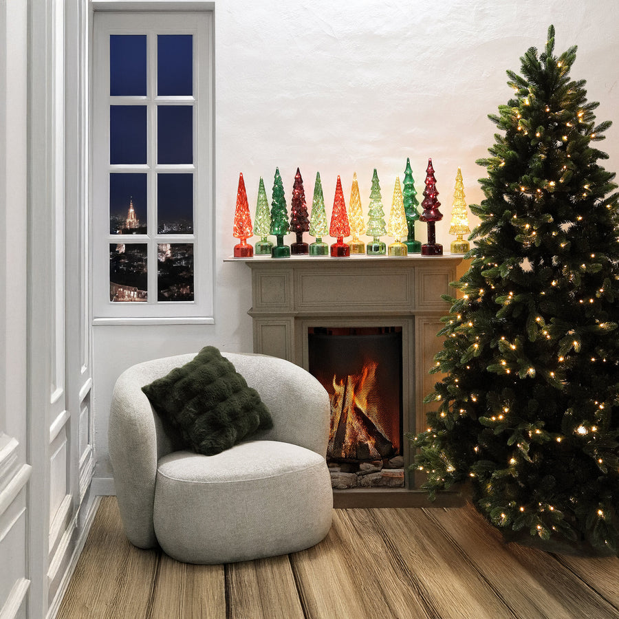 Glazen LED kerstbomen op de schouw, sfeerfoto met de gouden kerstboom