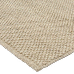 Detail van de handgeweven wollen structuur van het Boola vloerkleed Latte